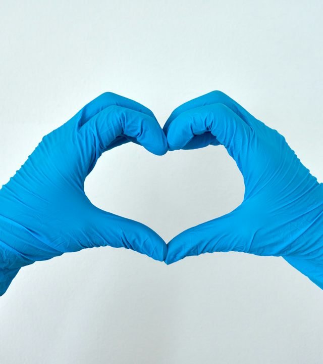 Cleaner in gloves making a heart shape